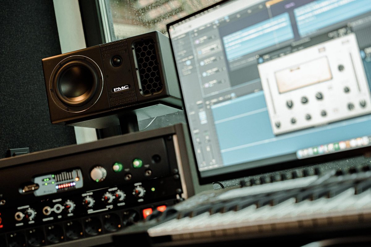 A studio monitor and outboard beside the desk
